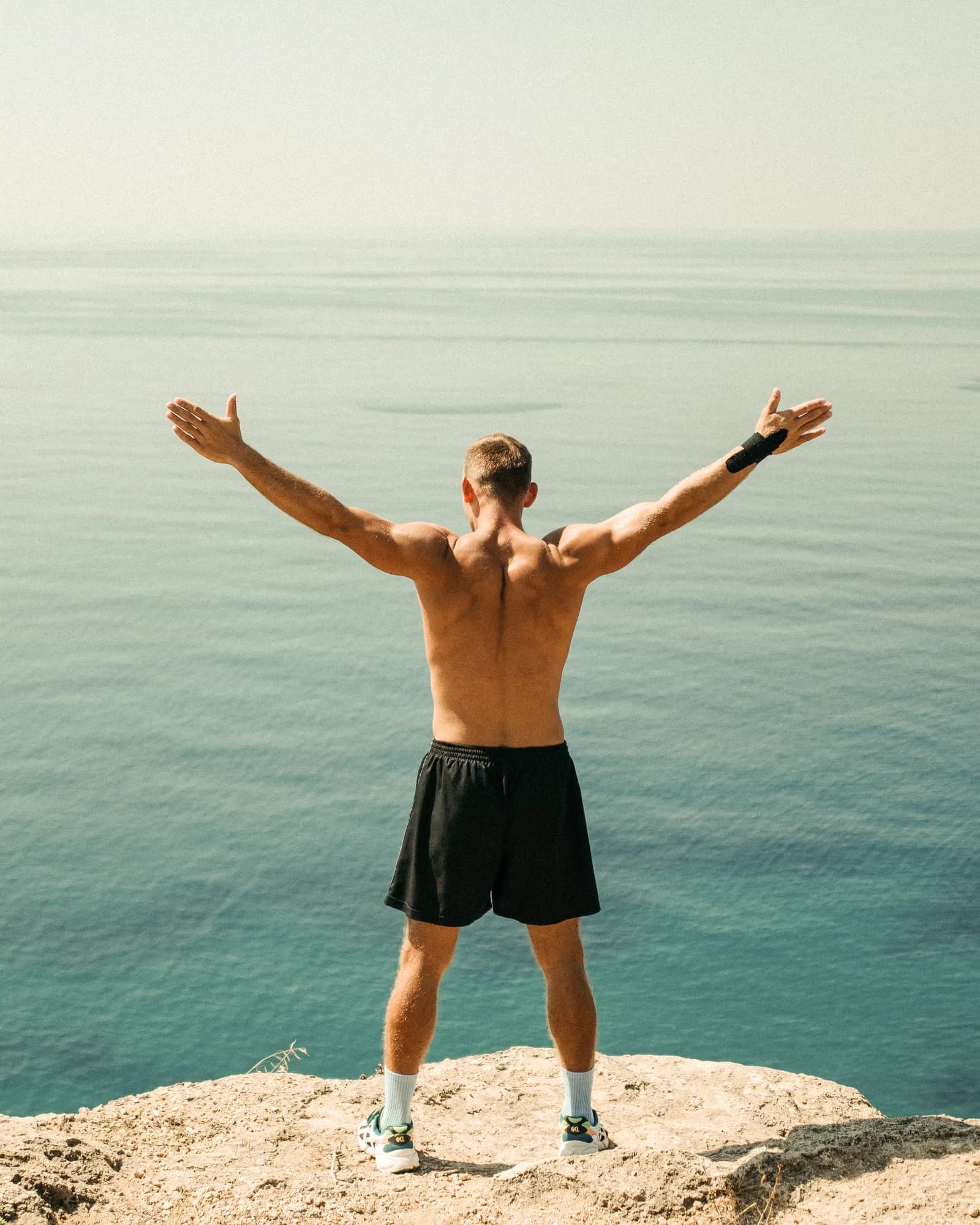 Un hombre con los brazos abiertos frente al mar